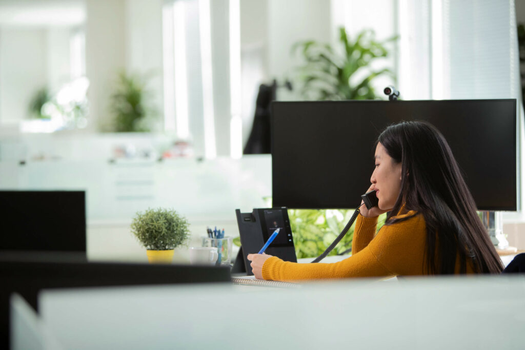 Woman on phone discussing small business phone calls via voip cloud phone system